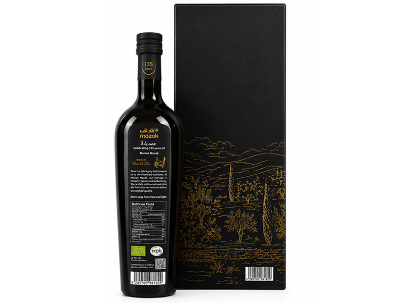 Mazak Heritage Edition bottle beside its gift box with a gold illustration of the village